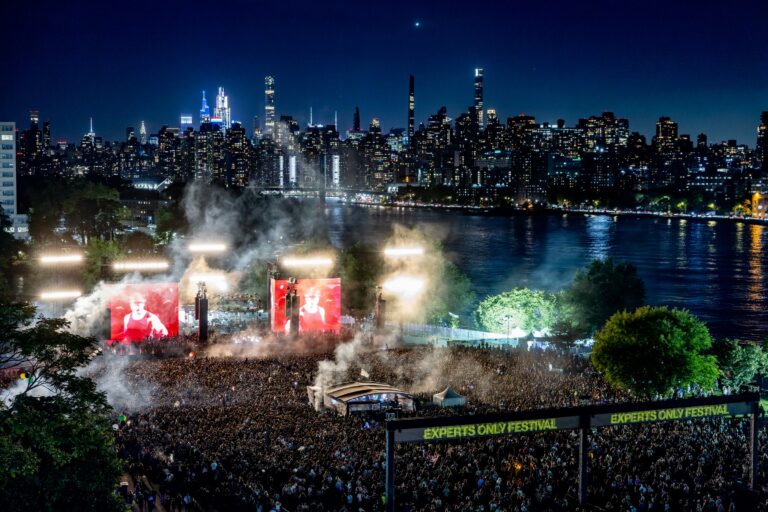 Experts Only Festival main stage crowd at Randall’s Island Park at night with the Manhattan skyline behind