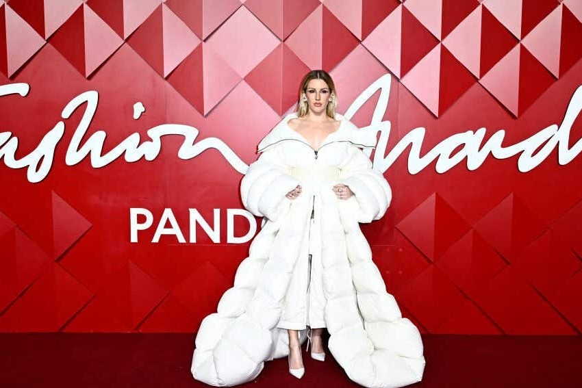 Ellie Goulding on the red carpet at The Fashion Awards 2024 in London, wearing an oversized white puffer coat