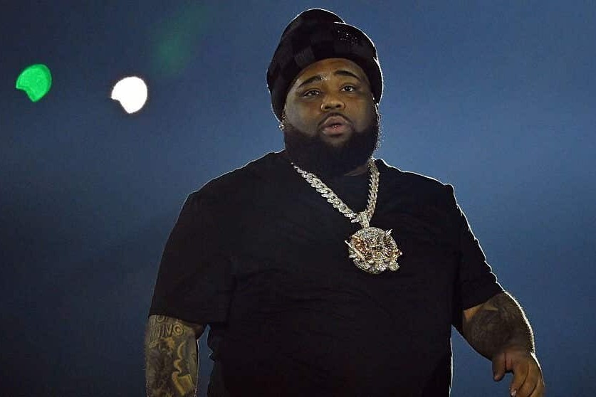 Rod Wave performs onstage in a black t-shirt and diamond chain during his Redemption Experience tour